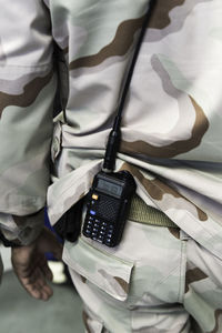 Midsection of soldier with walkie-talkie