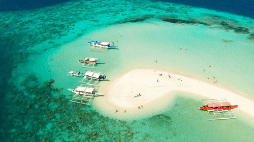 Tropical beach on island ditaytayan. tropical island with white sand bar, palm trees and green hills