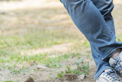 Low section of man standing on field