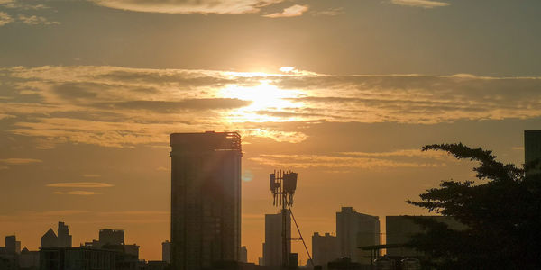 Silhouette buildings against sky during sunset