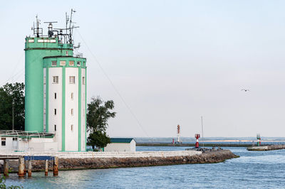 Lighthouse by sea against sky