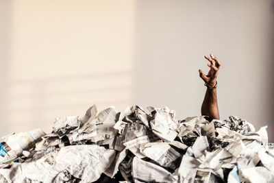 Man's hand in stack of magazines