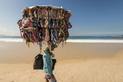 Vendor on beach against sky