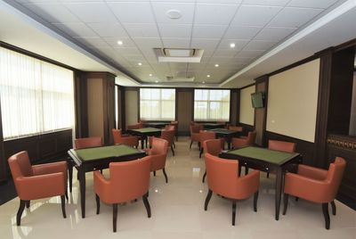 Empty chairs and tables in illuminated room