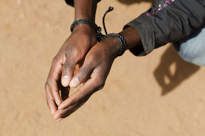 High angle view of hands on sand