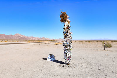 Umbrella on desert against clear sky on sunny day