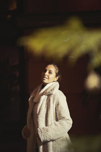 Portrait of young woman wearing warm clothing while standing outdoors