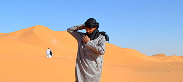 Man standing in desert against clear sky