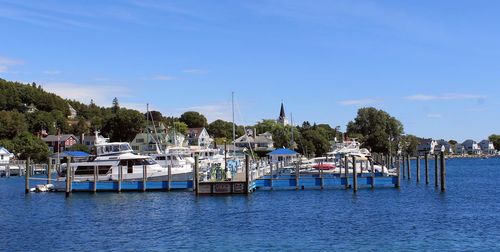 Boats moored on sea against blue sky