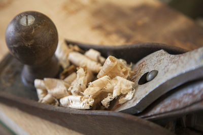 Close-up of chisel with shavings on wood