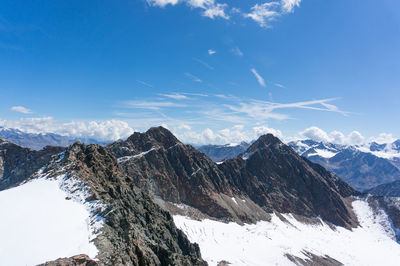 Scenic view of snowcapped mountains against blue sky