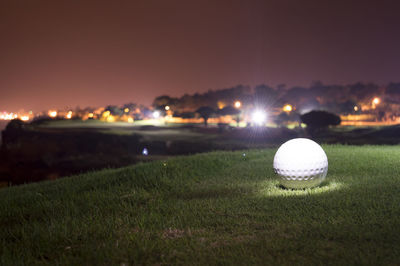 Close-up of illuminated ball on grass at night