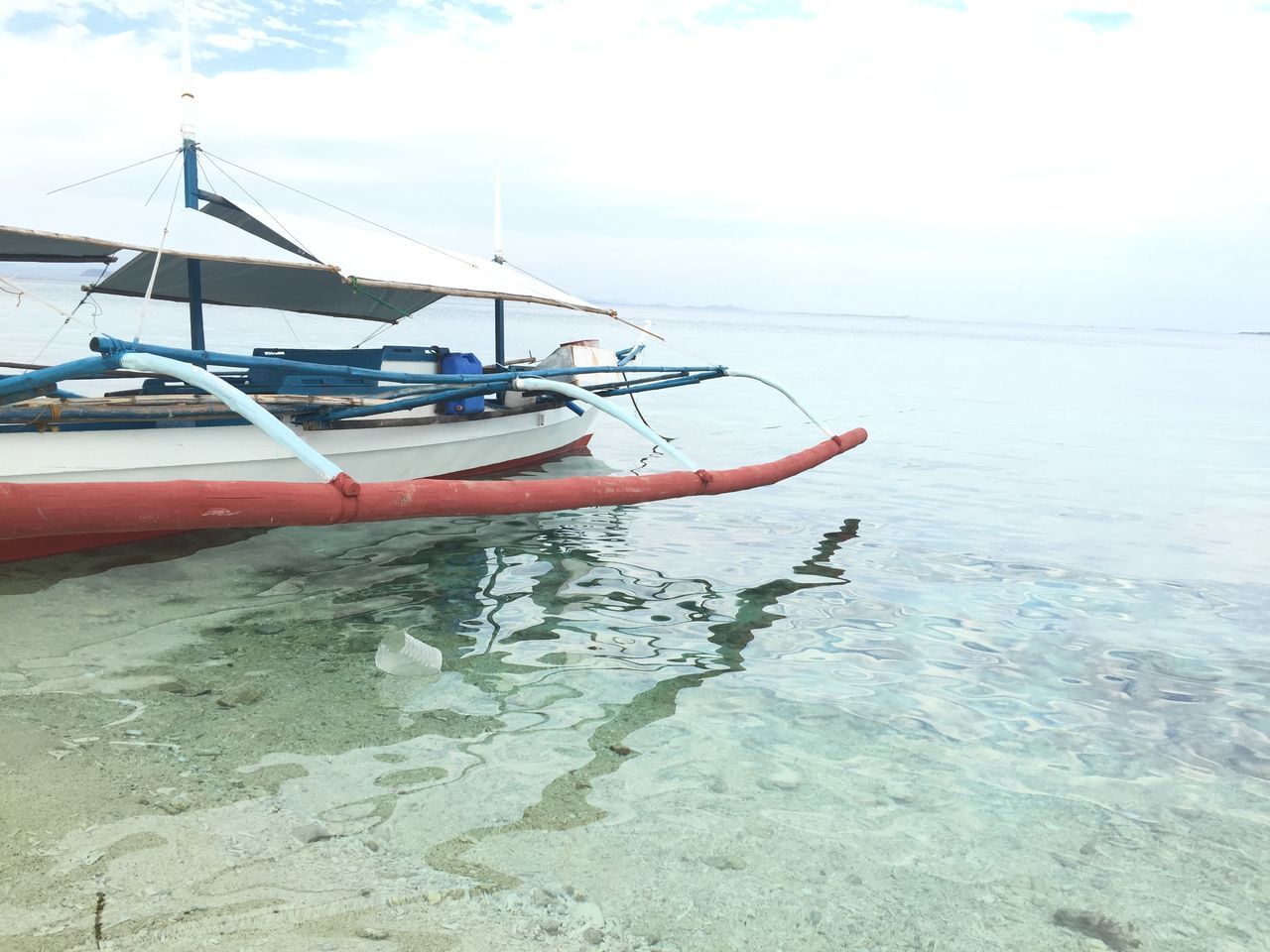 BOATS MOORED IN SEA AGAINST SKY