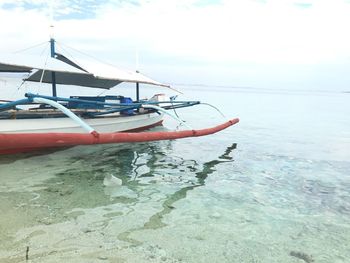 Boat moored on sea against sky