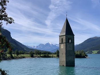 Lago di resia - italy church by building against sky