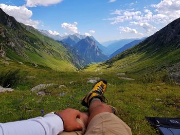 Low section of man in mountains against sky