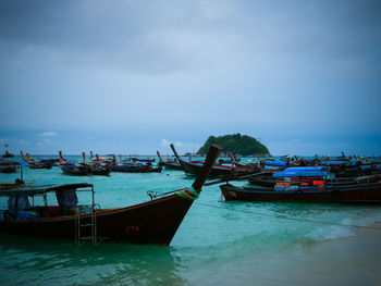 Boat moored on shore against sky