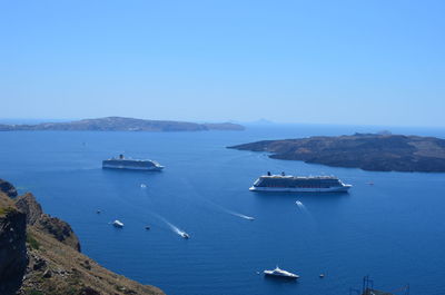 Cruise ships and yachts in sea against clear sky