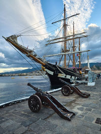 Ship moored at harbor against sky