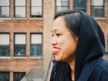 Portrait of happy young woman on balcony