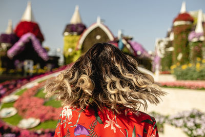 Rear view of young woman in ornamental garden at dusk