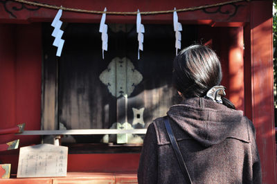 Rear view of woman standing at home