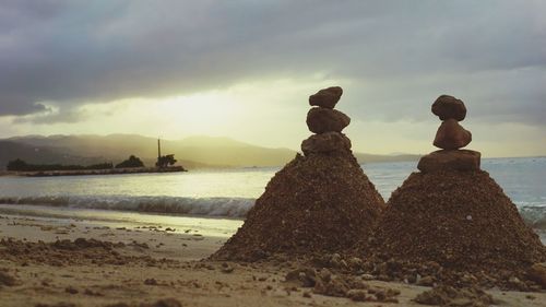 Rear view of people at beach against sky