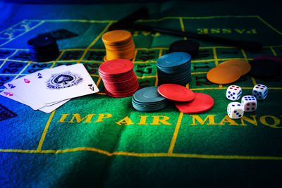 Close-up of gambling chips with cards and dice on table in casino