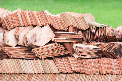 Full frame shot of chopped stack of wood in grass