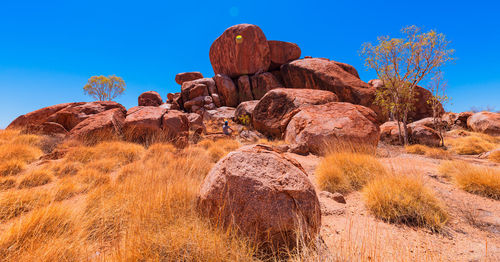 Rock formation on landscape against blue sky