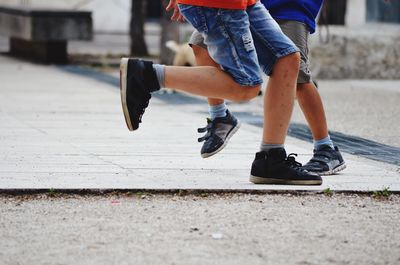 Low section of two children playing on road