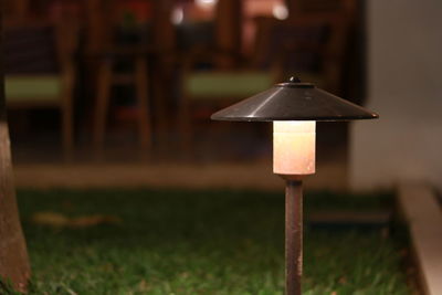 Close-up of electric lamp on table in field