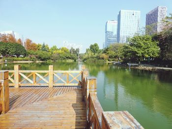 Pier over lake in city against sky