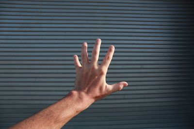 Cropped image of hand against wall