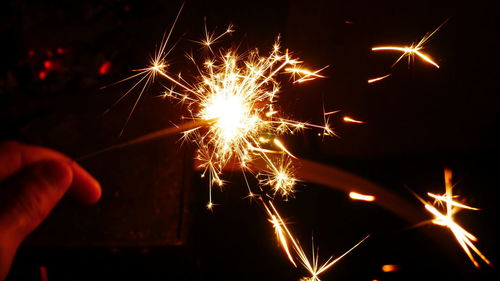 Person holding sparkler at night