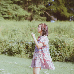 Side view of young woman standing on field