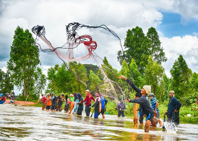 People on shore against sky