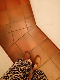 Low section of man standing on tiled floor