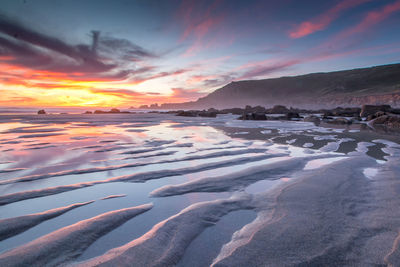 Scenic view of beach against sky during sunset 