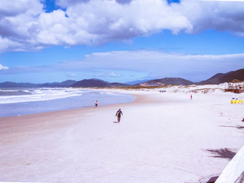 People on beach against sky