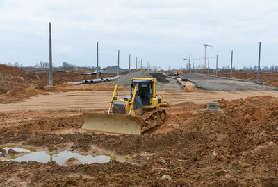 Tractor at construction site against sky