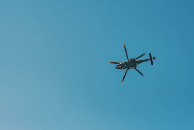 Low angle view of airplane against clear blue sky