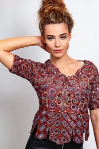 Portrait of young woman standing against gray background