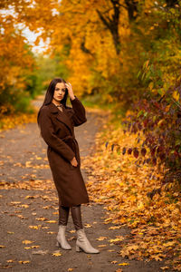 Portrait of a young woman in a brown coat in autumn