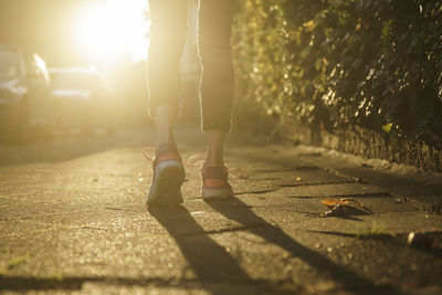 Legs of woman jogging on walkway at sunset