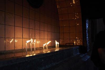 Rear view of woman standing by illuminated light