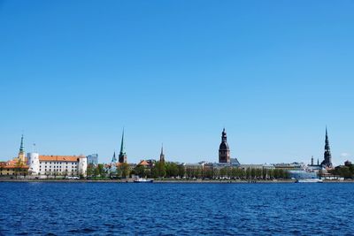 View of buildings in city against blue sky