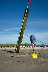 Lifeguard hut on beach against blue sky