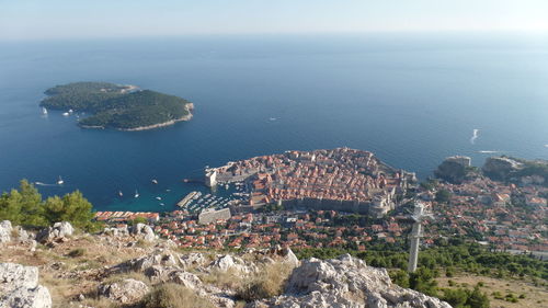 High angle view of sea by cityscape against sky