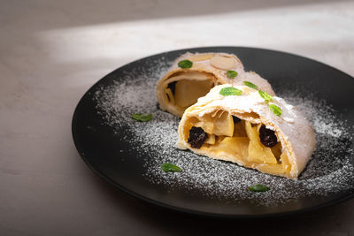 Close up of apple austrian strudel with cinnamon and mint on a plate